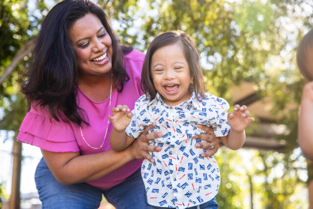 Latina mother holding child with Down syndrome